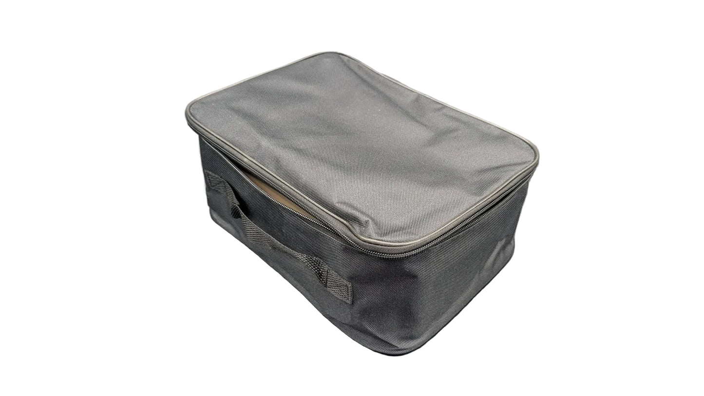 A gray zippered fabric storage bag or organizer case with a top handle, shown on a gray surface with reflective silver light panels in the background.